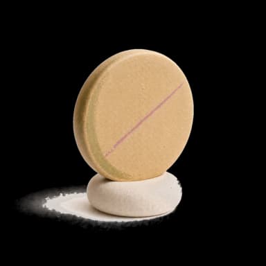 A ceramic coin balanced on a stone — calm money tools